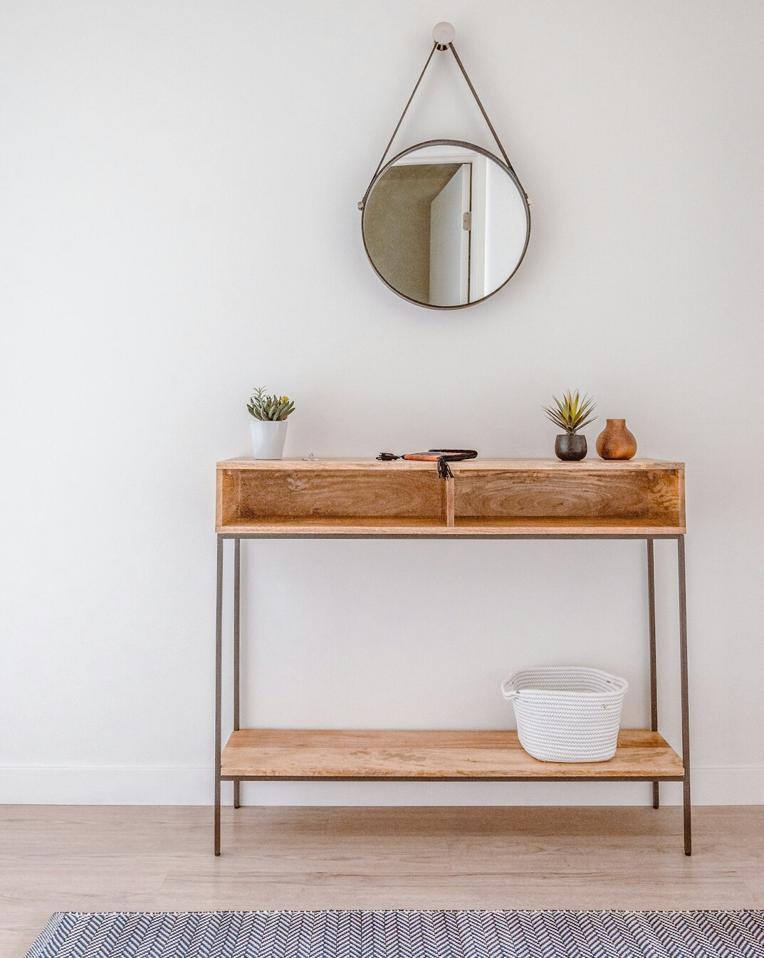 Bright home hallway with a wooden console table and baskets