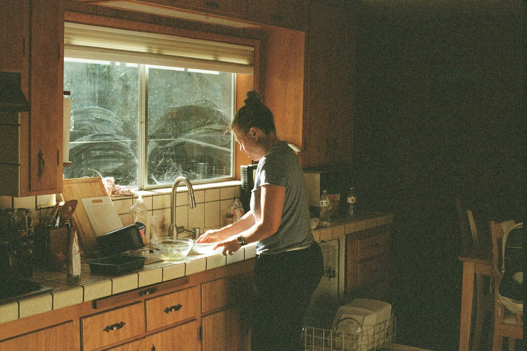 person tidying kitchen