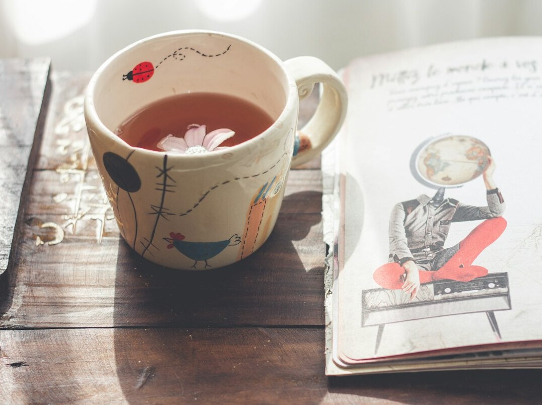 Weekly planner open on a desk next to a cup of tea